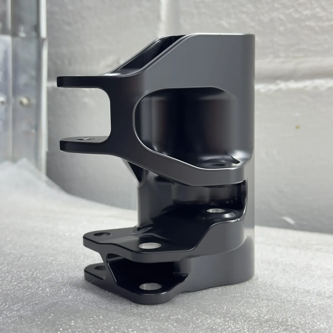 Black Cerakote machined bracket with bores left bare